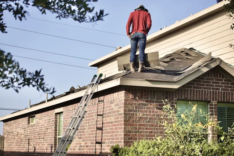 Professional roofer working on a residential roof in West Hollis